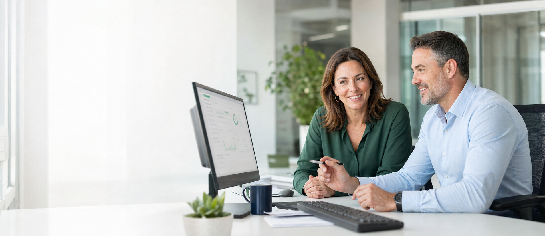Two professionals collaborating on credit union software in a bright modern office